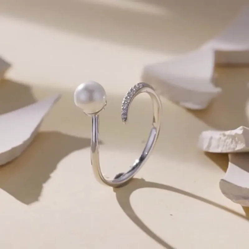 S925 sterling silver adjustable ring with a natural shell pearl on an open loop band.
