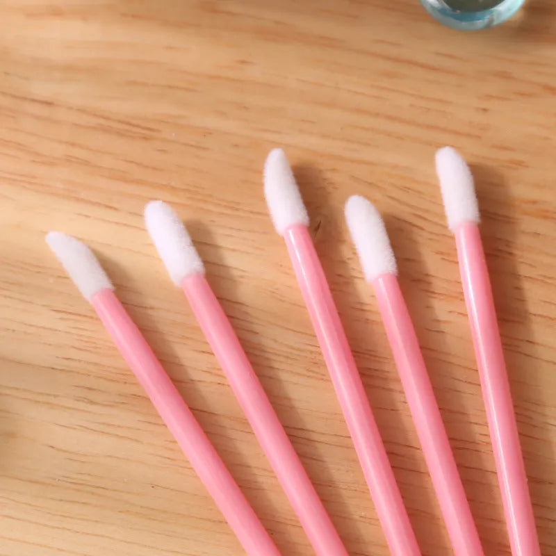 Pack of disposable lip brush applicators with coloured handles and flocked brush tips on a white background
