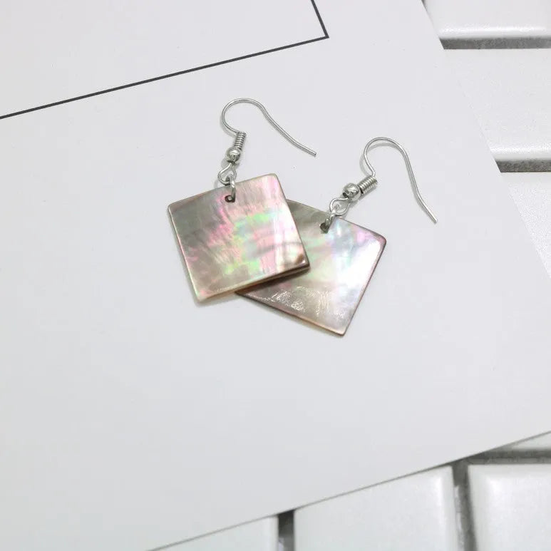 A pair of geometric-shaped earrings made from shell in a retro style, showing colour options.