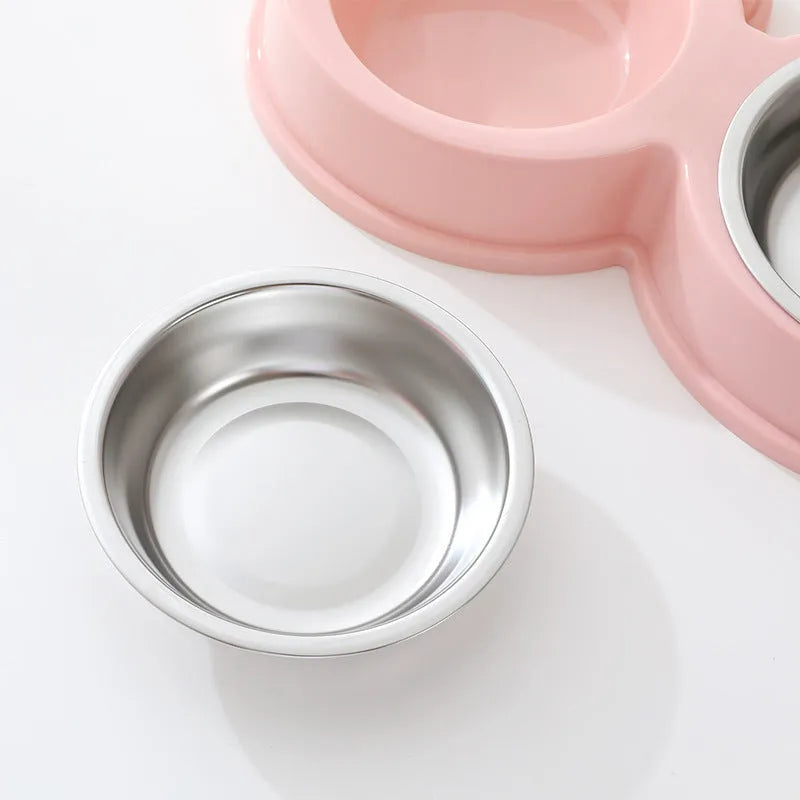 Frog-shaped plastic holder containing two stainless steel pet bowls for food and water.