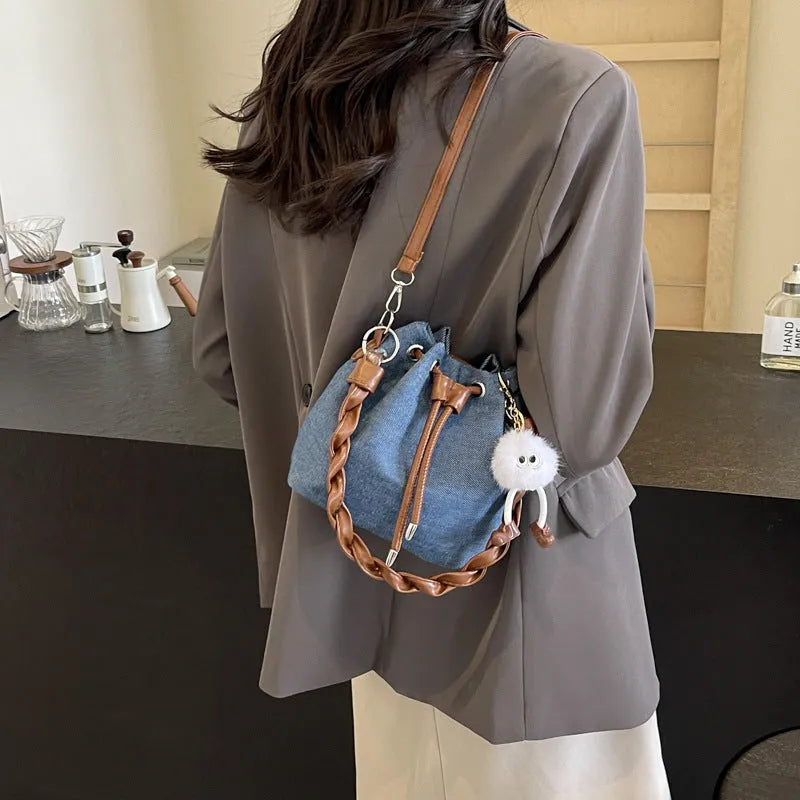Blue cross body bucket messenger bag with synthetic leather lining and sandwich pocket organisation