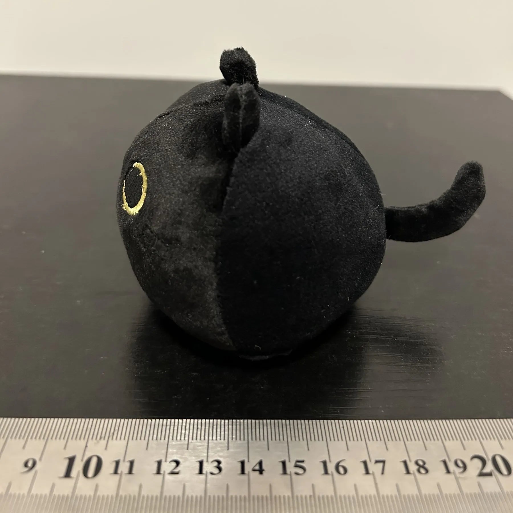 Black cat plush toy with fluffy fur and cushion design for napping