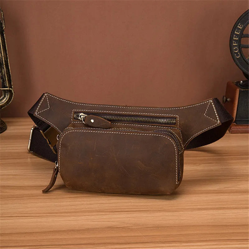 Brown cowhide leather men's sports waist bag with pull closure, shown with phone and laptop compartments.
