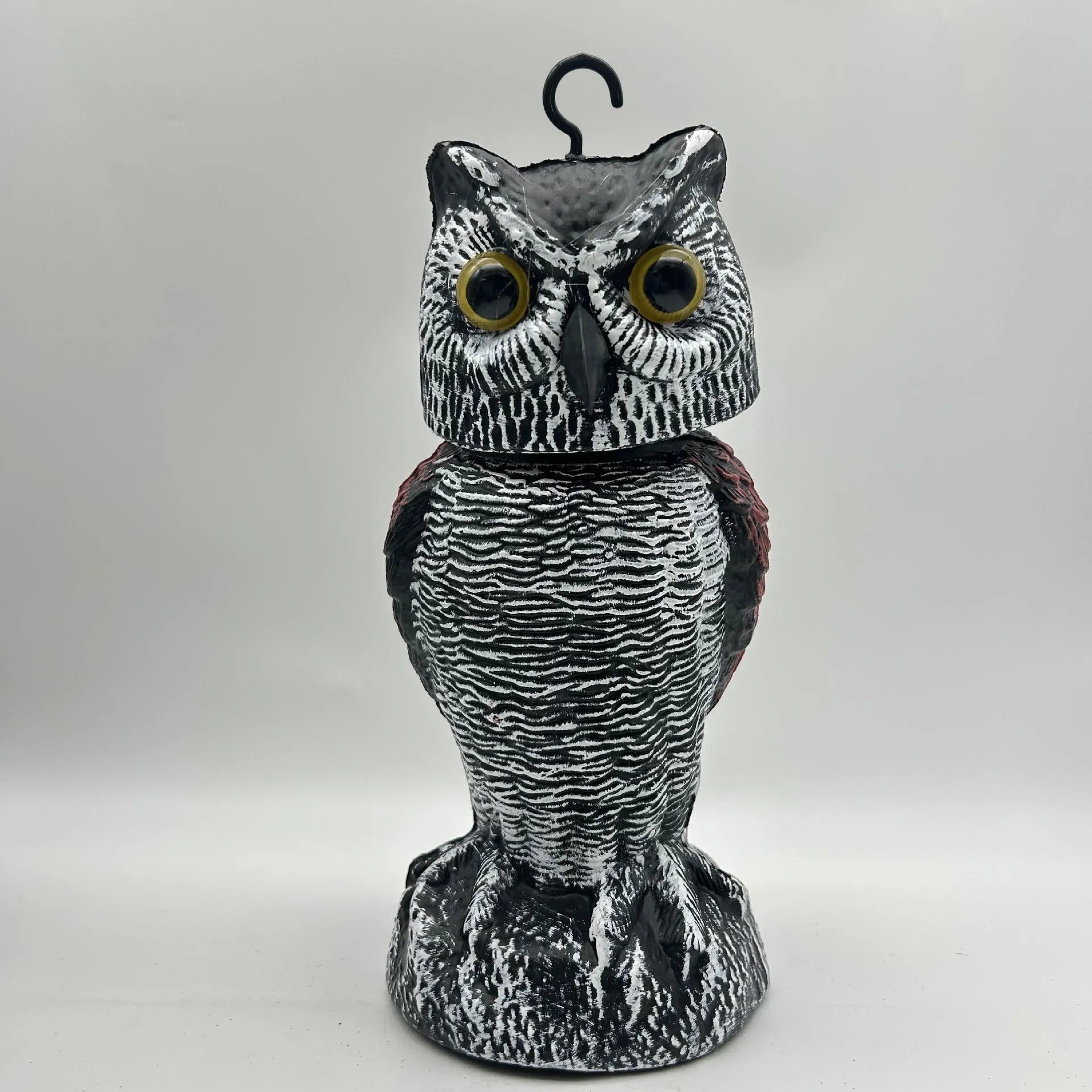Artificial owl bird scarer decoy with shaking head motion in outdoor setting