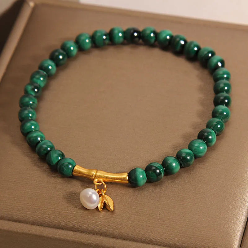 Women's white crystal bracelet with a high-rise lucky bamboo design on a wrist.