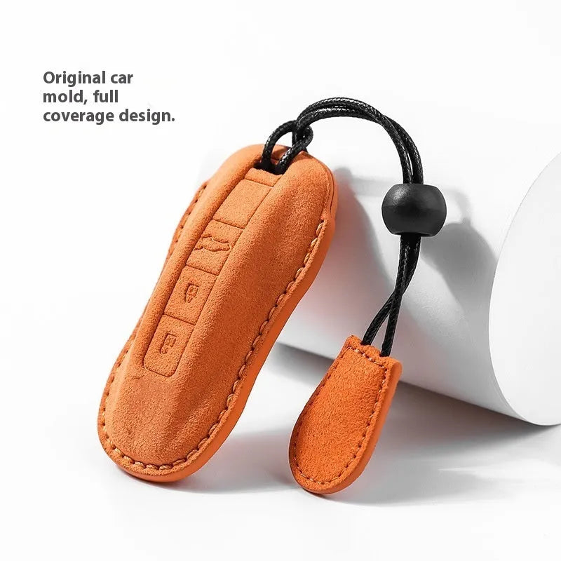 Suede car key cover in cement grey, dark green, light grey, and orange colour options.