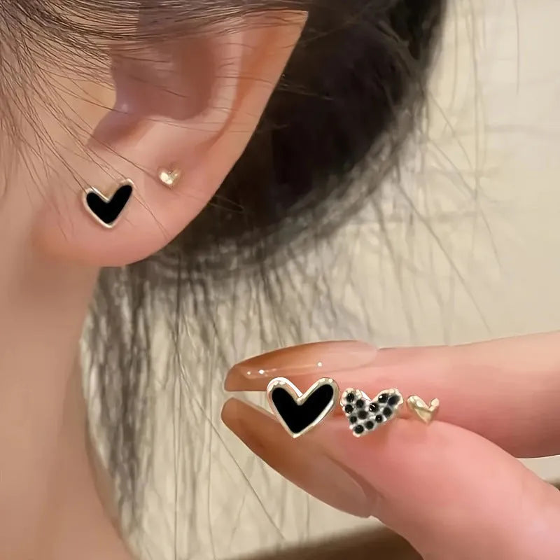 Women's heart-shaped earring set with three pairs in gold, black, black and white, and pink electroplated colours