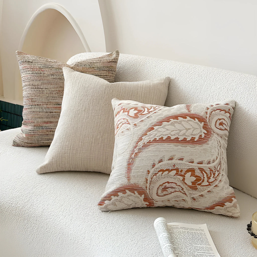 American-style jacquard pillow cover with paisley and flower pattern in amber colour, shown on a sofa.