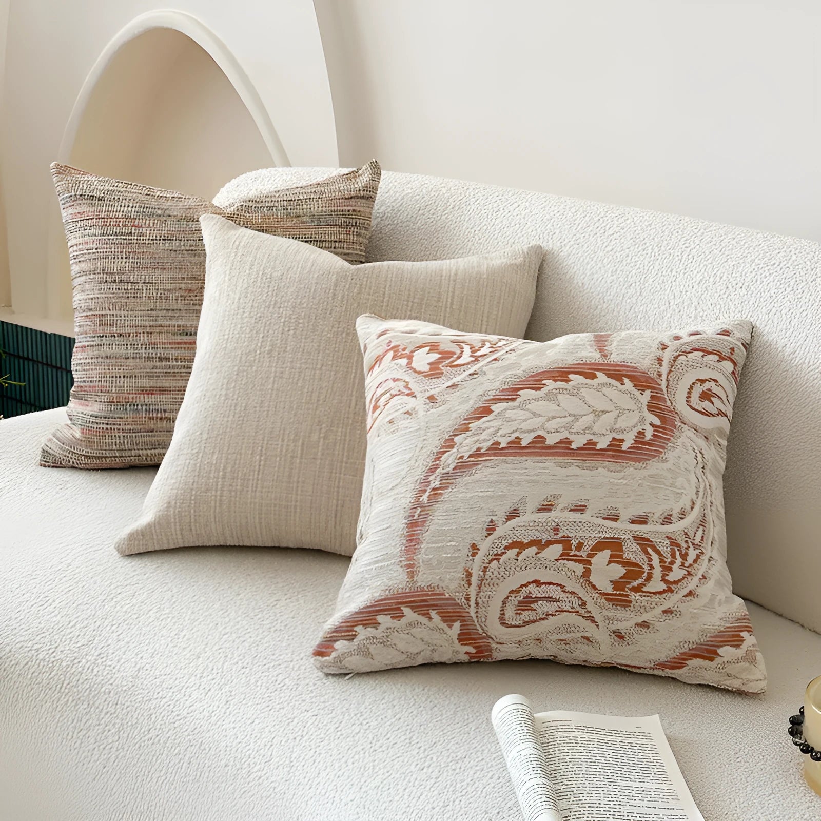 American-style jacquard pillow cover with paisley and flower pattern in amber colour, shown on a sofa.