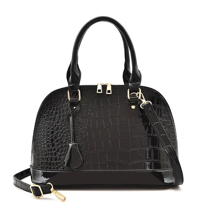 Shiny black PU crossbody bag showing structured shell shape and dimensions