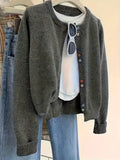 Dark grey solid colour women's polyester cardigan sweater with button front and long sleeves.