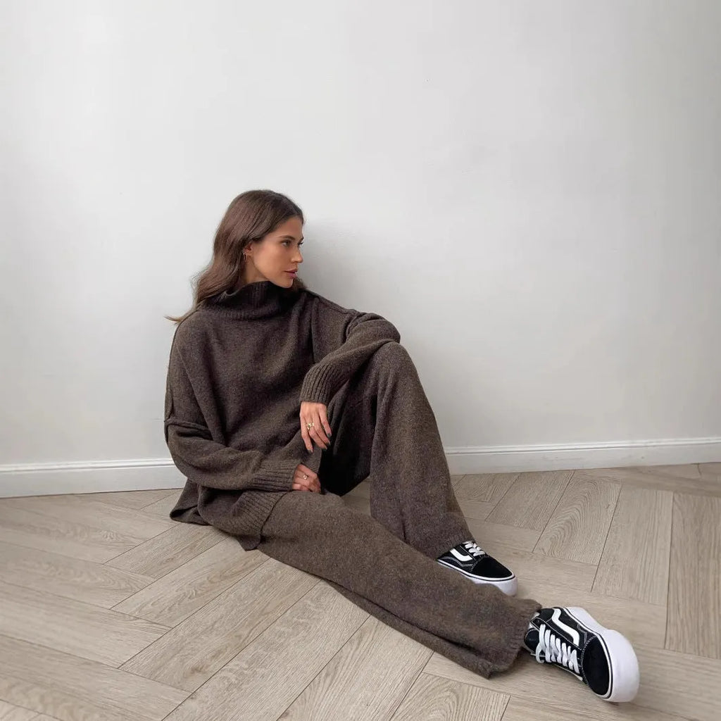 Women's knitted acrylic suit set with side-slit top and matching trousers in a solid colour.