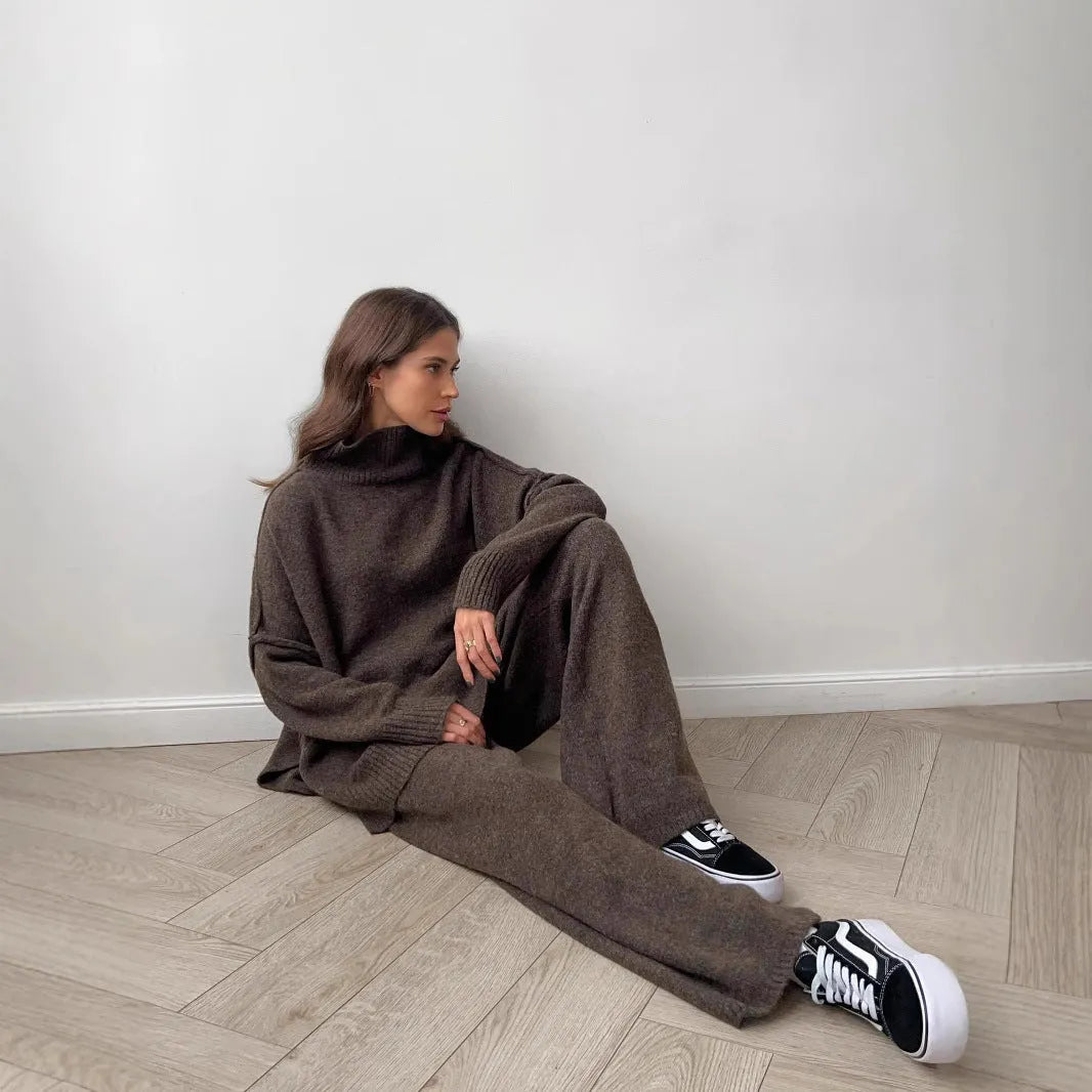 Women's knitted acrylic suit set with side-slit top and matching trousers in a solid colour.