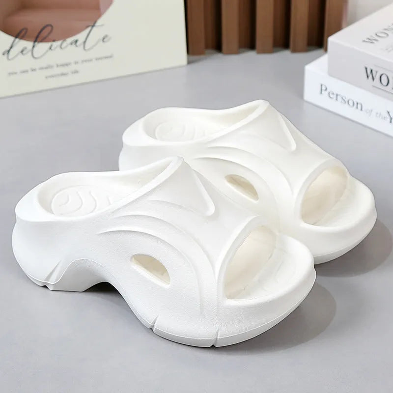 Women's white EVA slippers with a thick sole on a sandy beach background
