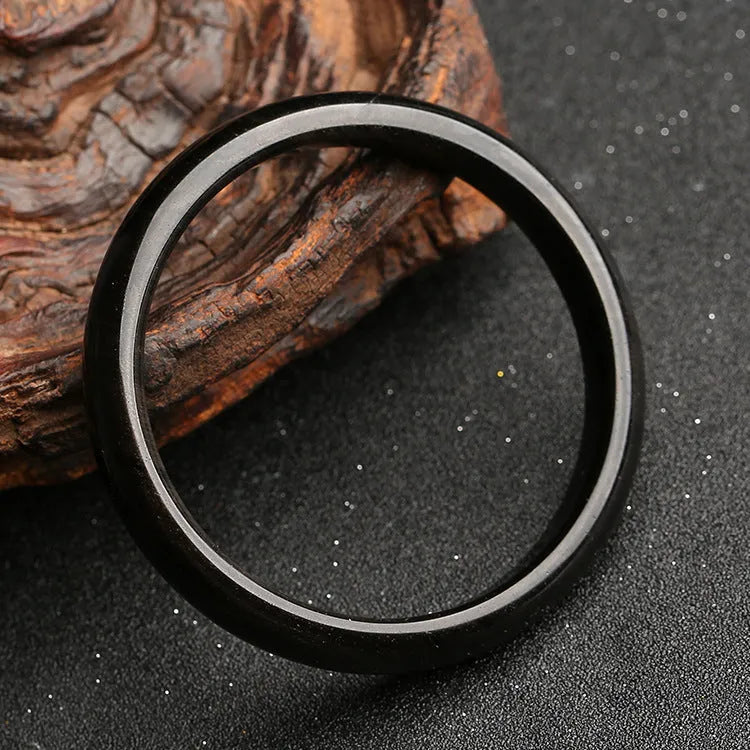 Natural silver stone cat's eye obsidian and alloy ethnic bracelet with geometric patterns on a wrist.