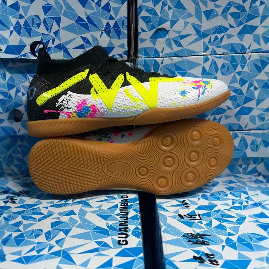 Low-top black and yellow football trainers with removable screw-in studs on the sole.