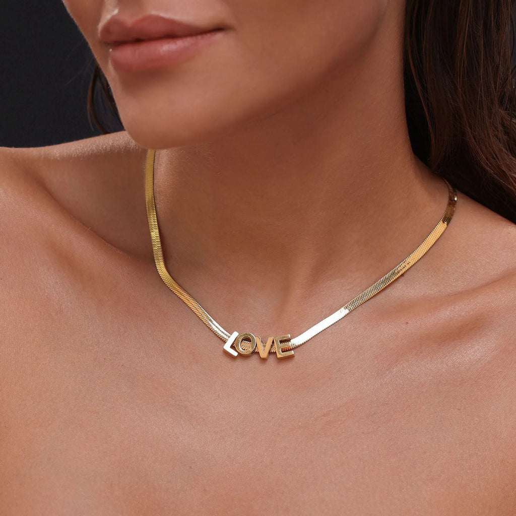 Gold and silver titanium steel initial number necklace with alphabet and number pendants on a 40.5cm chain.