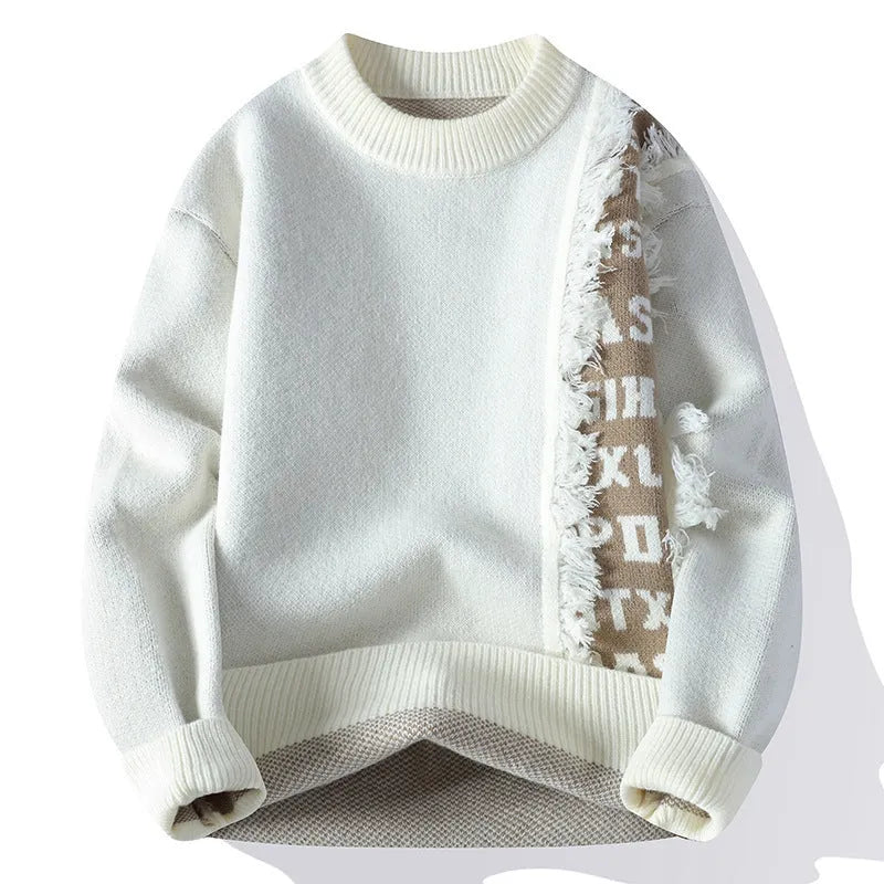 Man wearing a loose grey knitted pullover jumper with a ribbed hemline.