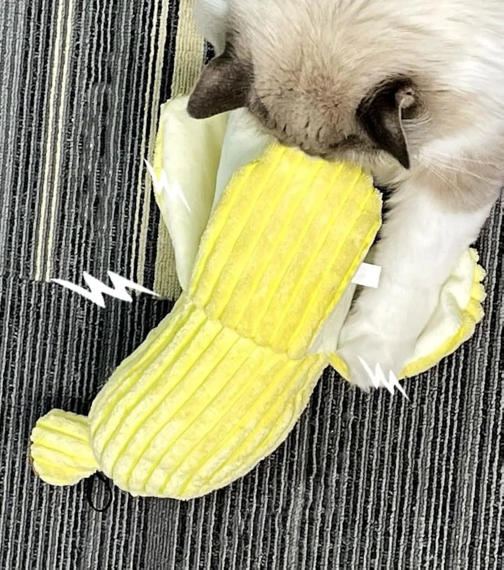 Yellow banana-shaped plush cat toy with a textured velvet strip, shown next to a cat for scale.