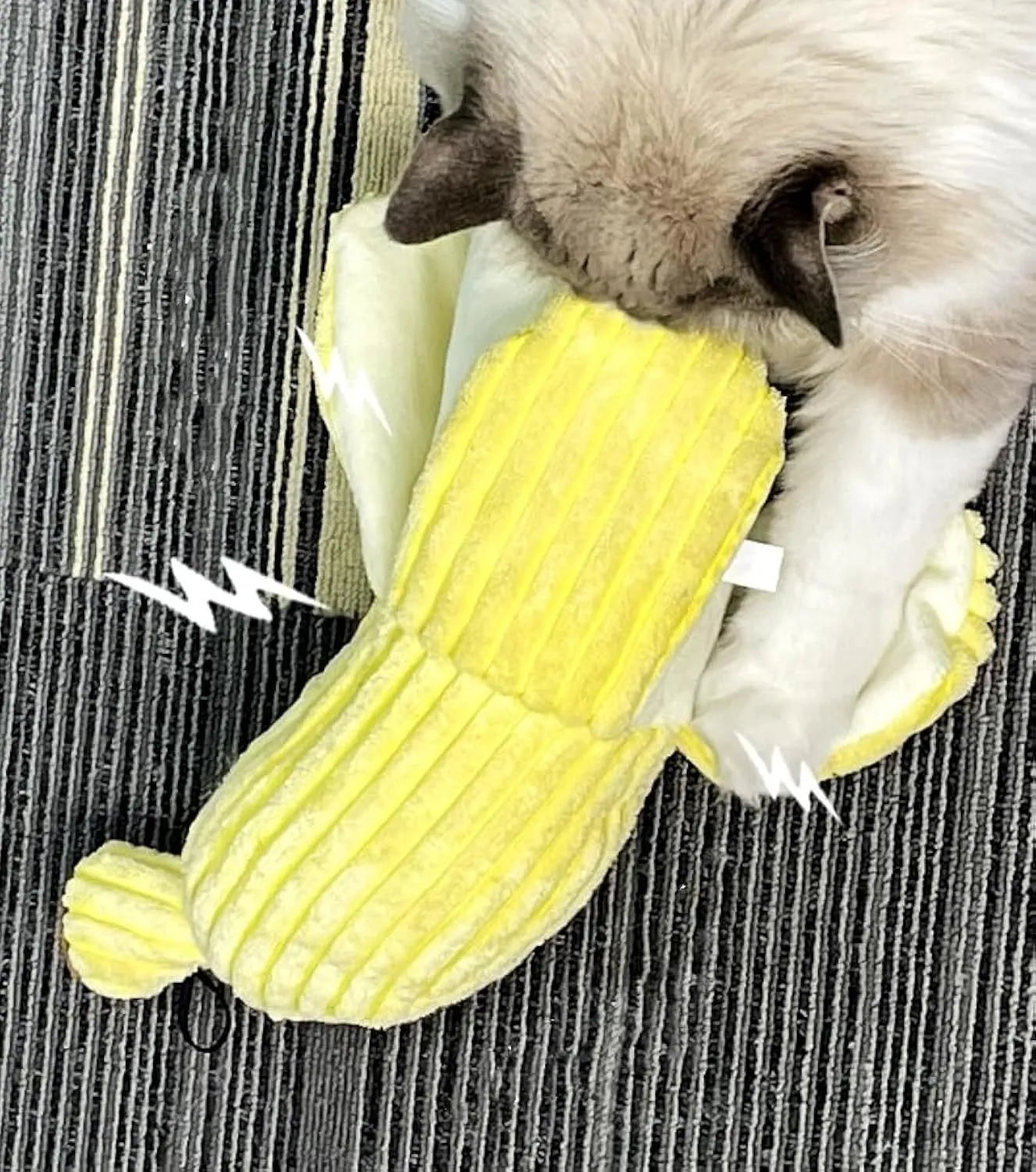 Yellow banana-shaped plush cat toy with a textured velvet strip, shown next to a cat for scale.