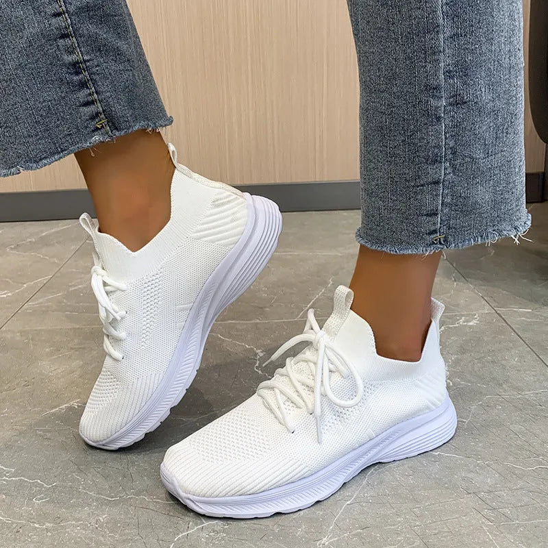 Women's low-top running shoes in Creamy White with mesh detailing and a flat rubber sole.