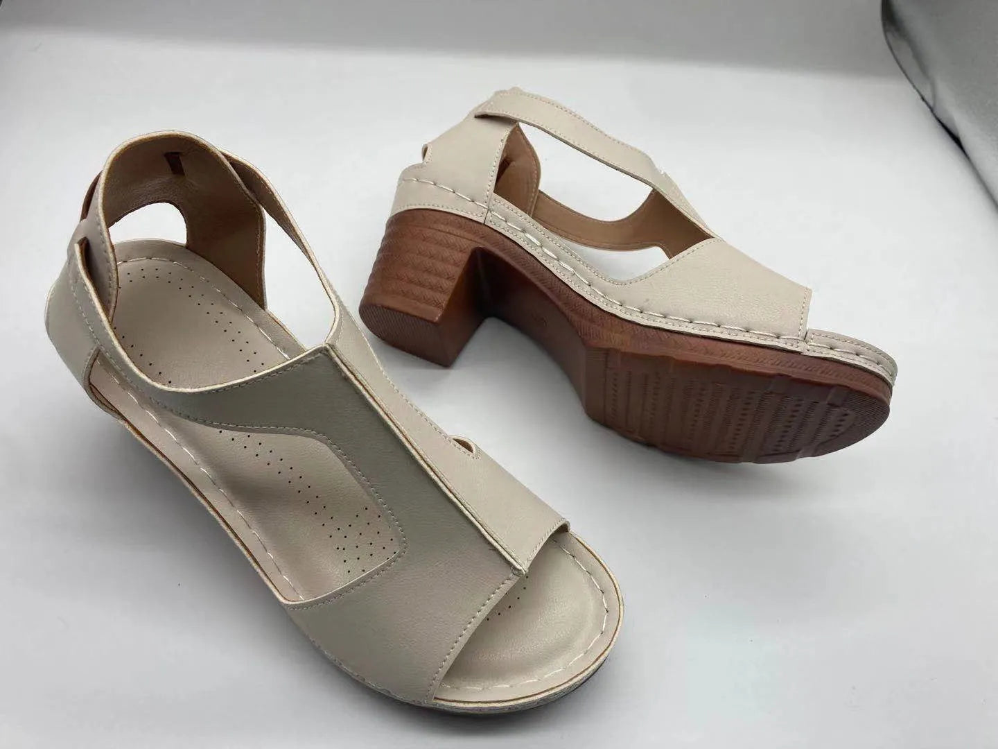 Women's peep toe wedge sandals with buckle detail, low heel, on a white background.
