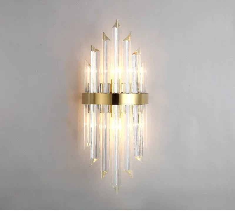 Modern crystal petal-shaped wall lamp in titanium gold finish mounted on a light-coloured wall.