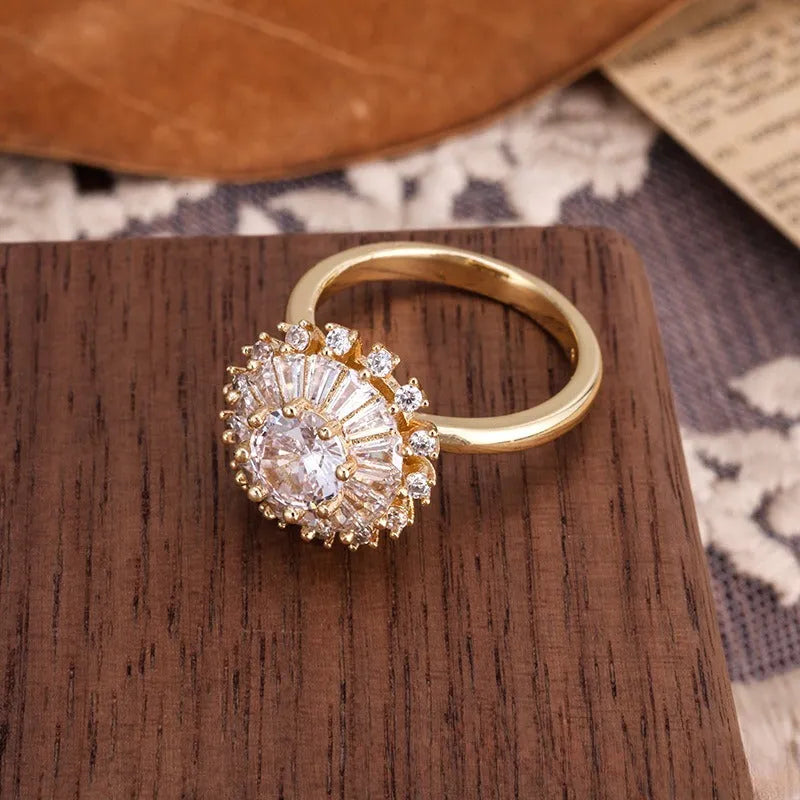 Gold electroplated copper flower ring with open mouth design on a plain background