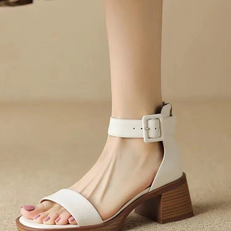 Women's white retro ankle-strap platform high heels with a round toe on a neutral background.