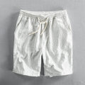 Man wearing black and white striped loose-fit casual cotton shorts with a mid waist.