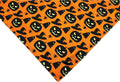 Black and orange reversible Halloween dog bandana with pumpkin and spider web patterns
