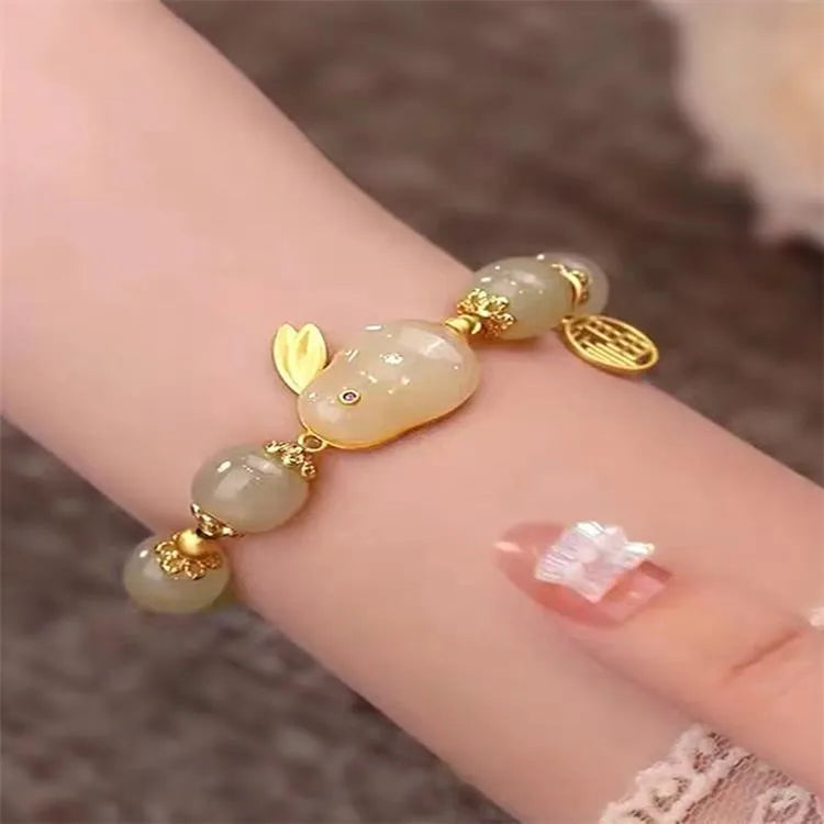 Green jade hare charm bracelet with black hand band showing lily engravings and fu character detail