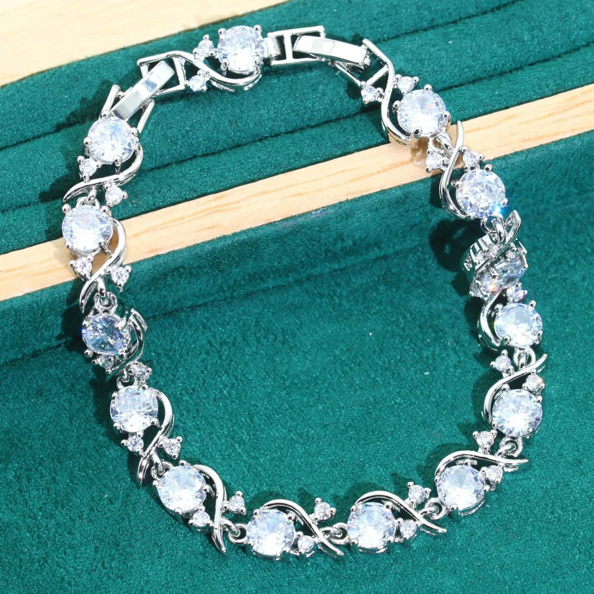 Four-piece bridal jewellery set showing zirconium alloy necklace, earrings, ring, and bracelet in water wave chain design.