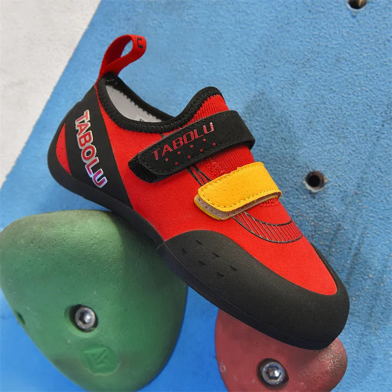 A pair of black and red rock climbing shoes with Velcro straps and a rubber sole.