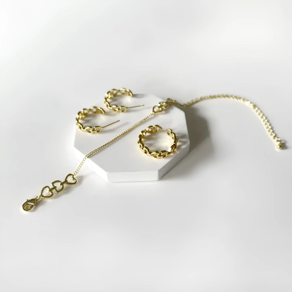 Minimalist Love Letter D geometric jewellery set including gold-plated earrings, ring, and bracelet on a light background