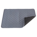 Grey and khaki washable waterproof dog pee pad on a wooden floor next to a pet crate.
