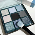 MUGELEEN nine-colour eye shadow palette showing matte and shimmer finishes in blue and smoked tones
