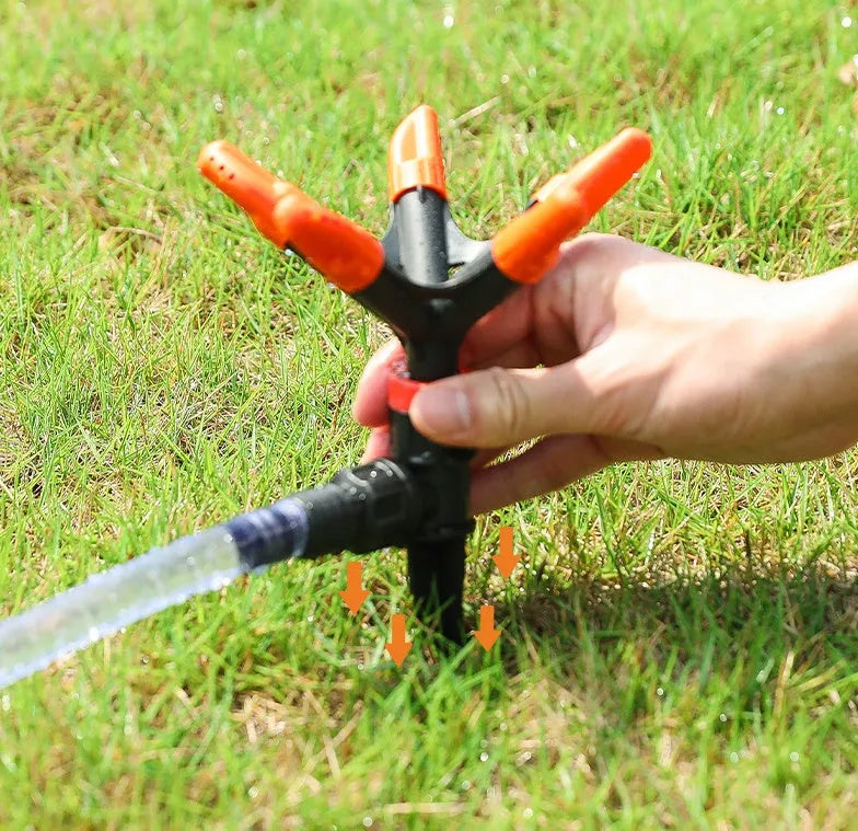 Automatic rotating garden sprinkler in orange plastic, size 14x26.5cm, on green lawn