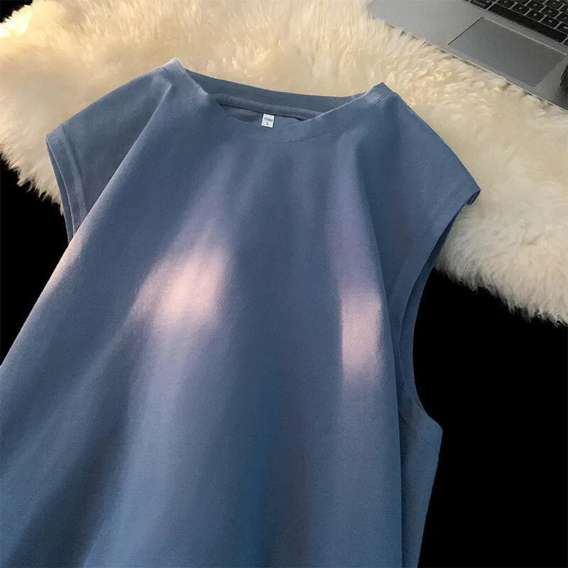Men's loose-fitting solid colour cotton tank top on a hanger, shown in a light colour.