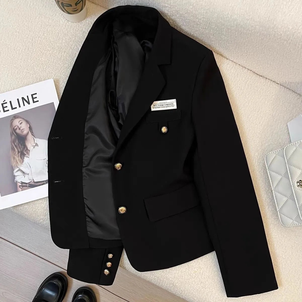 Black women's loose-fit suit coat with long sleeves and a pocket, made from polyester.