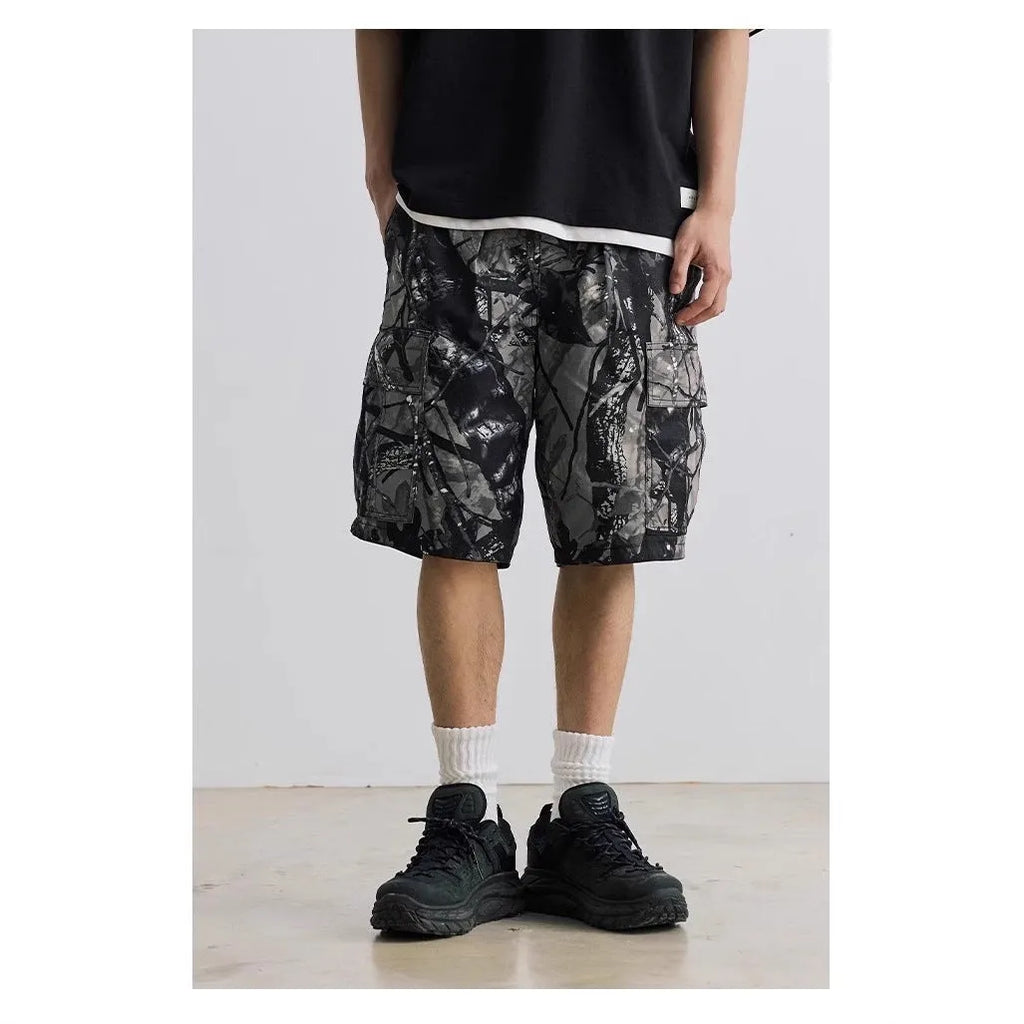 Man wearing loose straight-leg denim shorts in army green, showing mid waist and casual style.