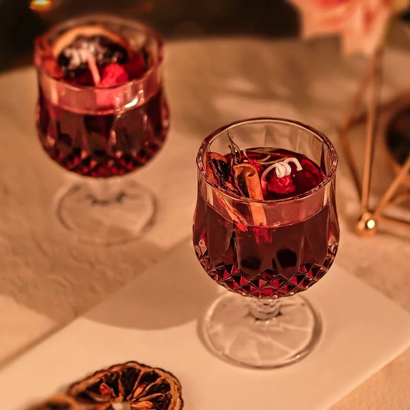 French mulled wine scented candle in a clear glass goblet on a table