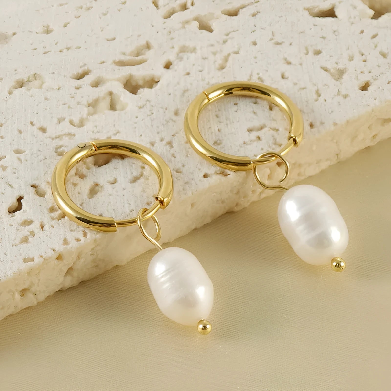 Pair of gold geometric earrings with pearl detail on titanium steel posts