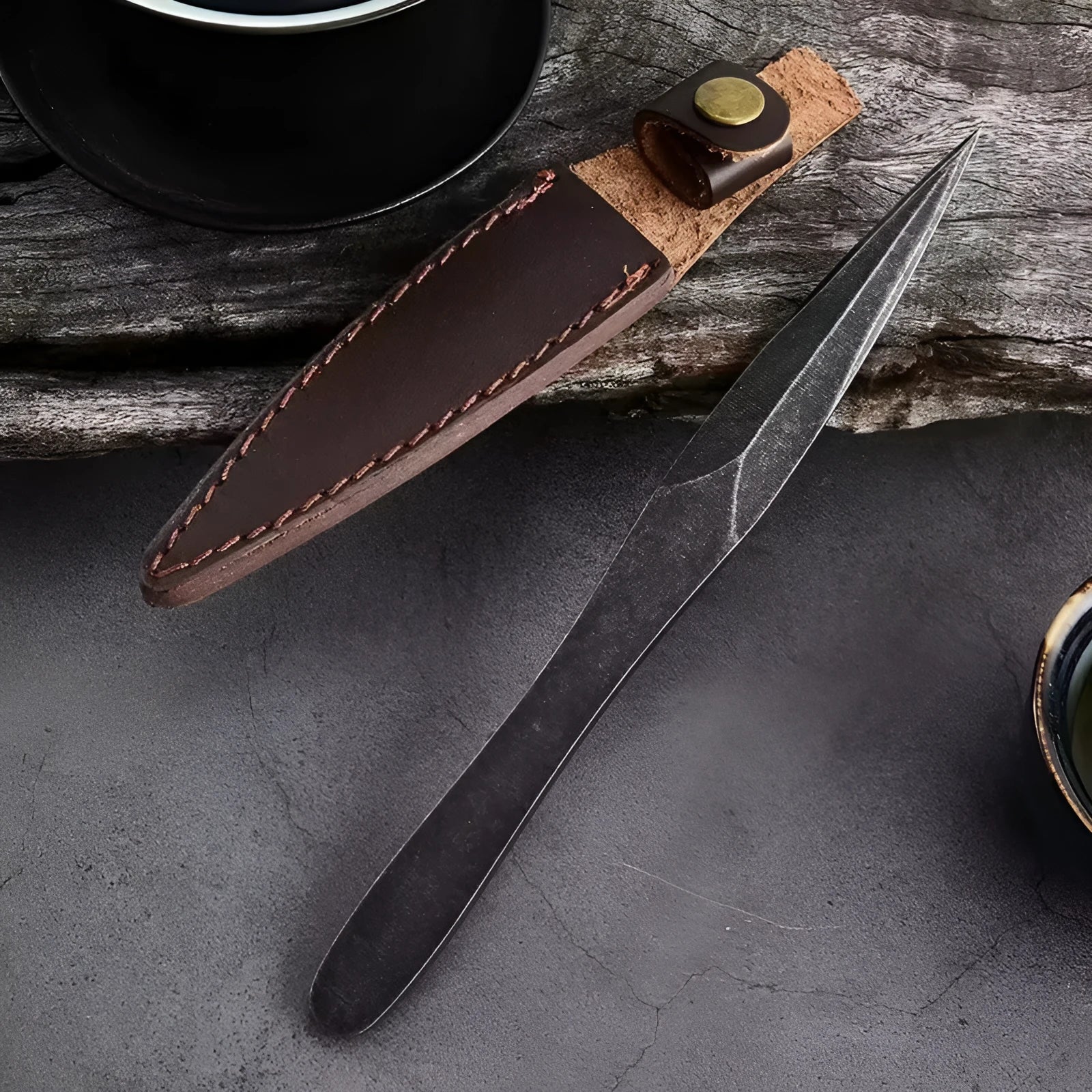 Black stainless steel hand pry tea knife with pointed blade on plain background