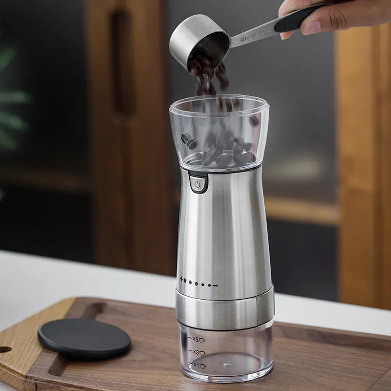 Electric coffee grinder stainless steel with USB charging cord and silver finish on tabletop