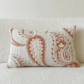 American-style jacquard pillow cover with paisley and flower pattern in amber colour, shown on a sofa.