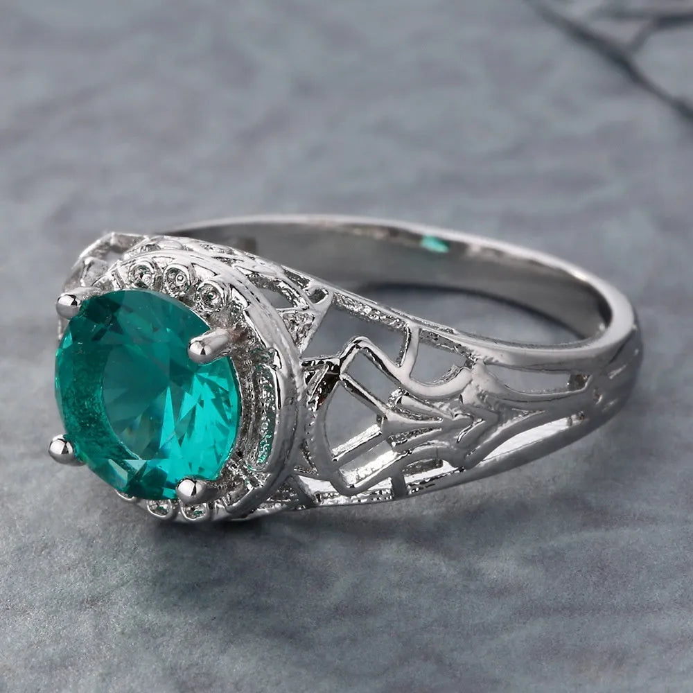 Silver electroplated copper ring with inlaid zircon stone on neutral background