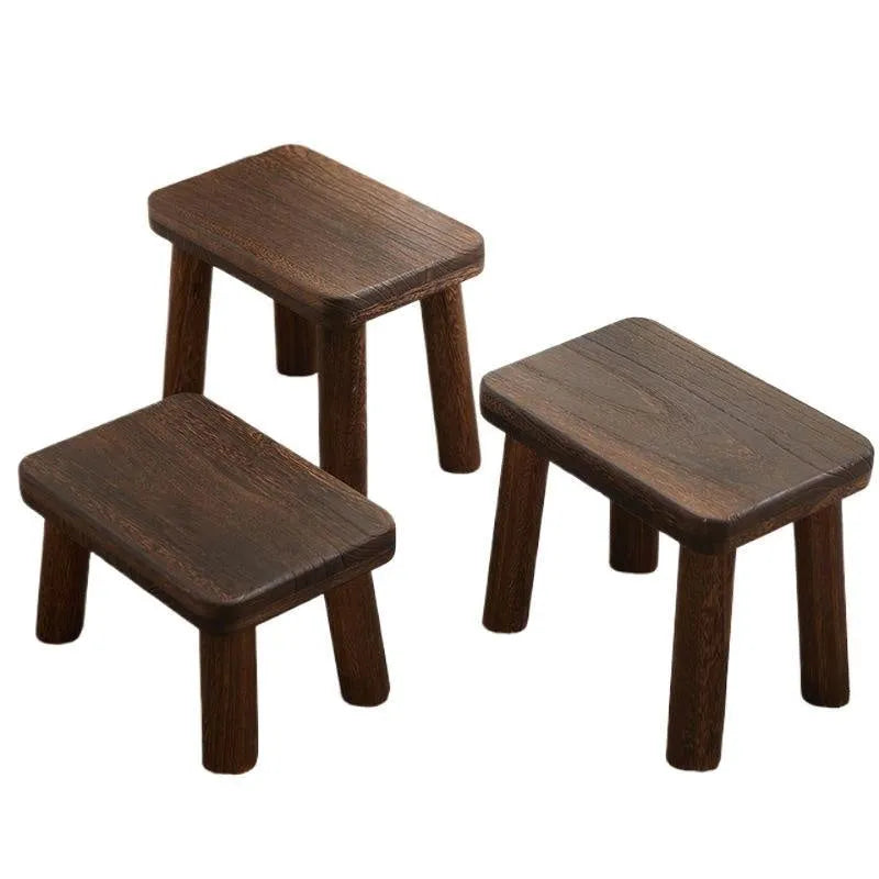 Solid wood shoe changing stool with a distressed rustic finish and sturdy bracket legs.