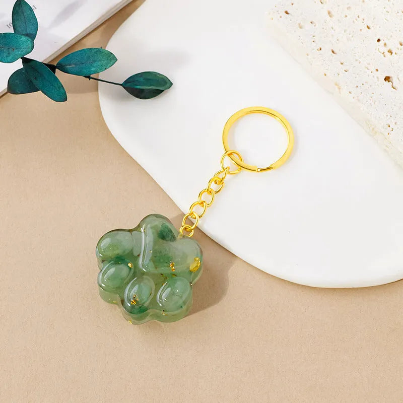 Small natural crystal cat's paw keychain pendant on a metal ring.