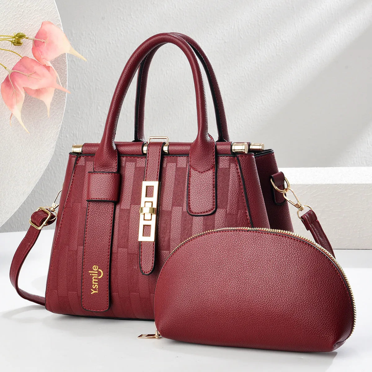 Round black PU handbag with crossbody strap shown alongside light khaki and purplish red colour options